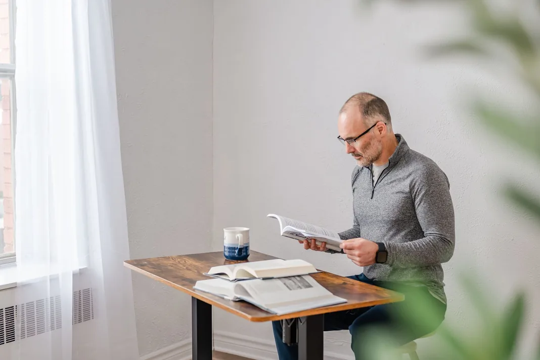 Marcel West at a table with a notebook and coffee, planning a coaching session