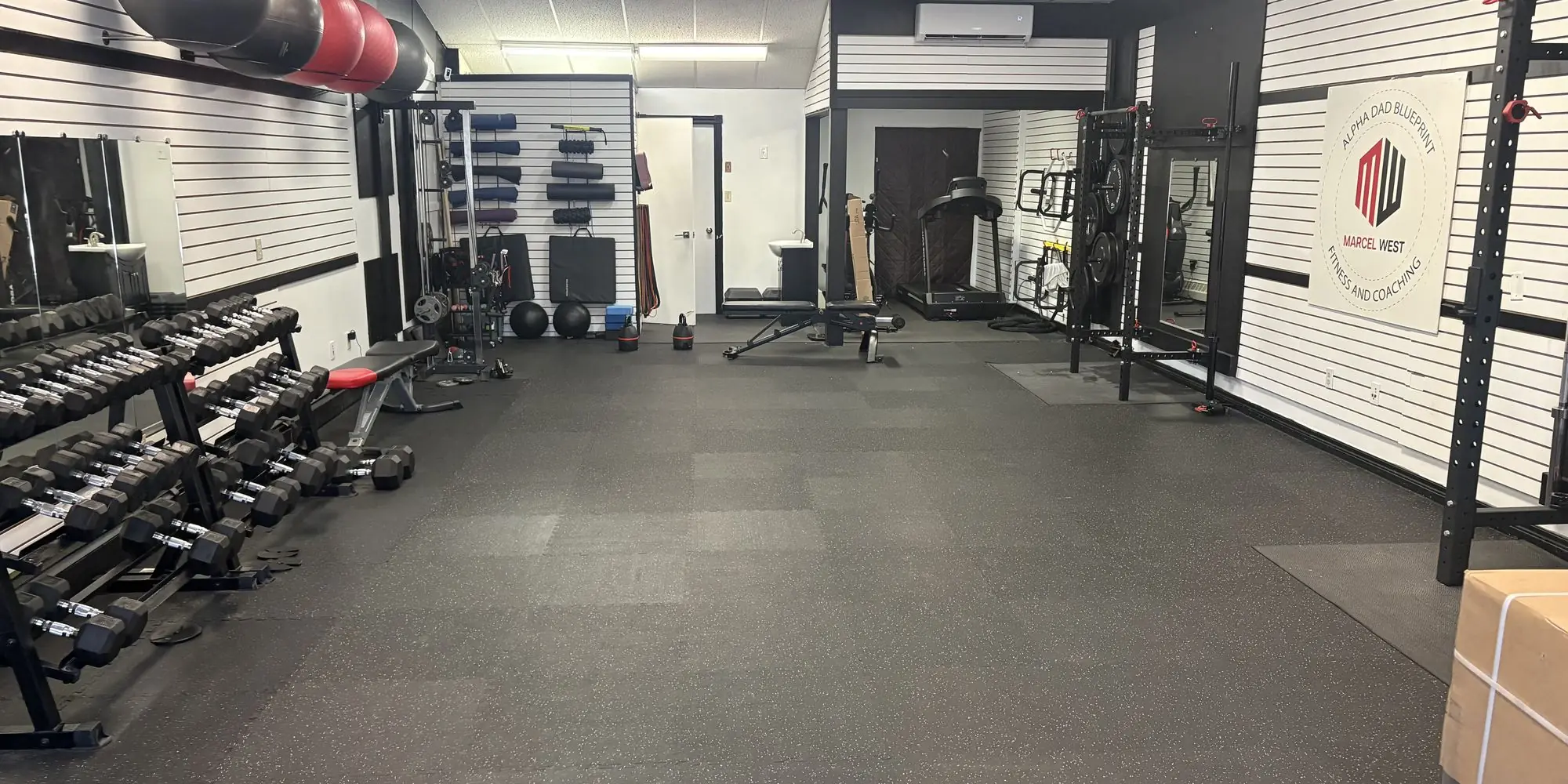 The open gym floor at MW Fitness and Coaching, with racks, dumbbells and open training space