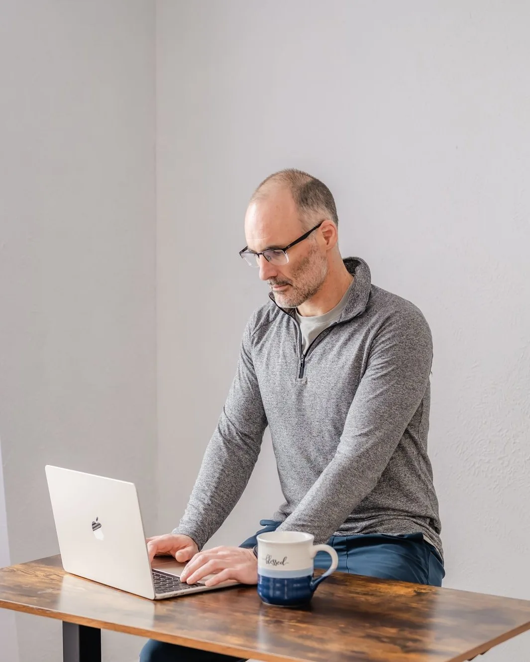 Marcel West at a desk with a laptop and a mug, running a virtual coaching session